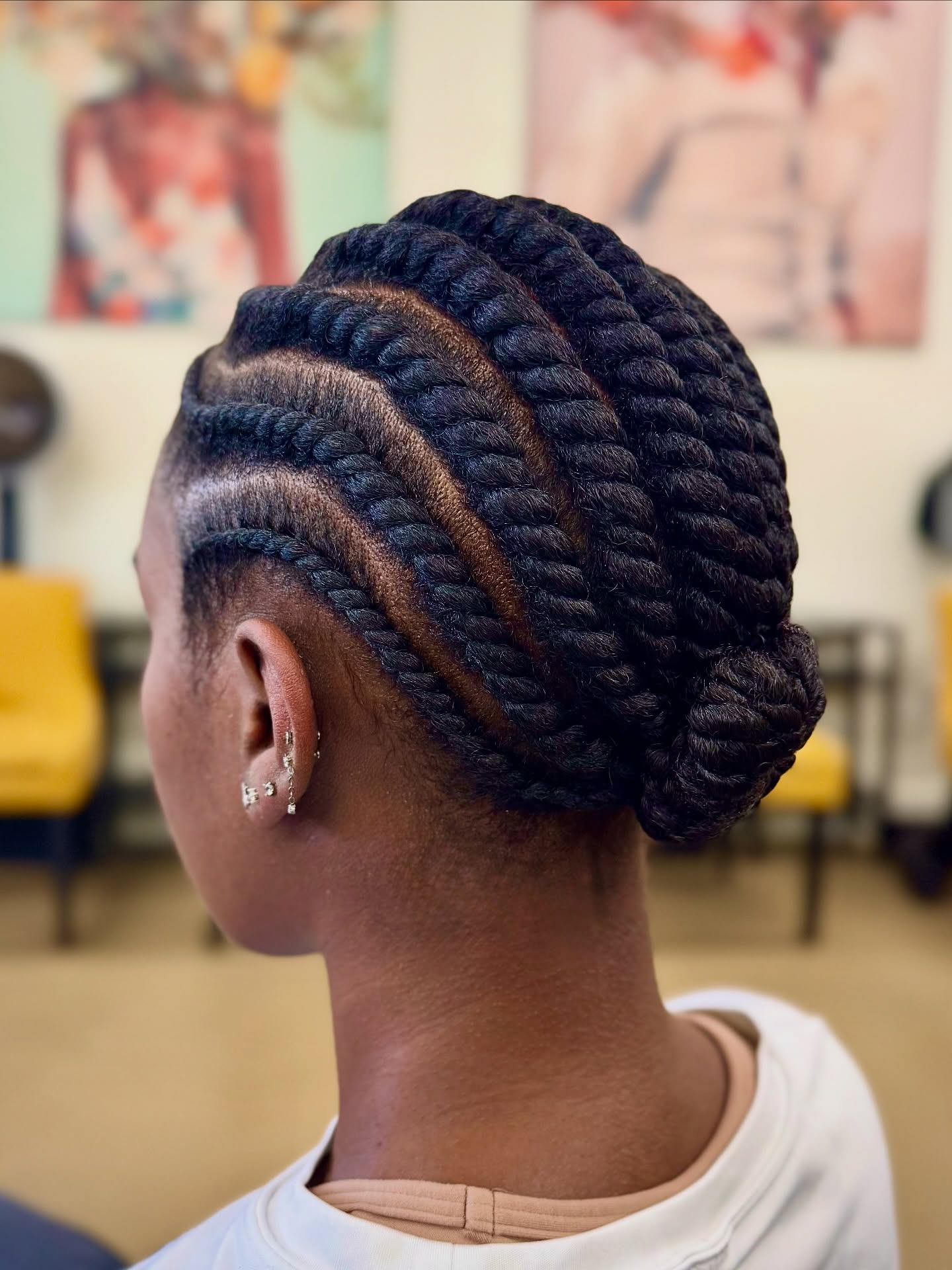 Chunky flat twists swept into a low bun at the nape
