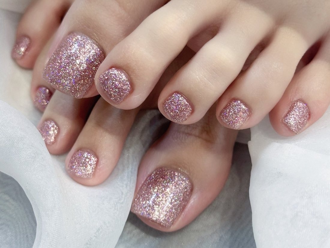 Toenails with fine champagne pink glitter polish