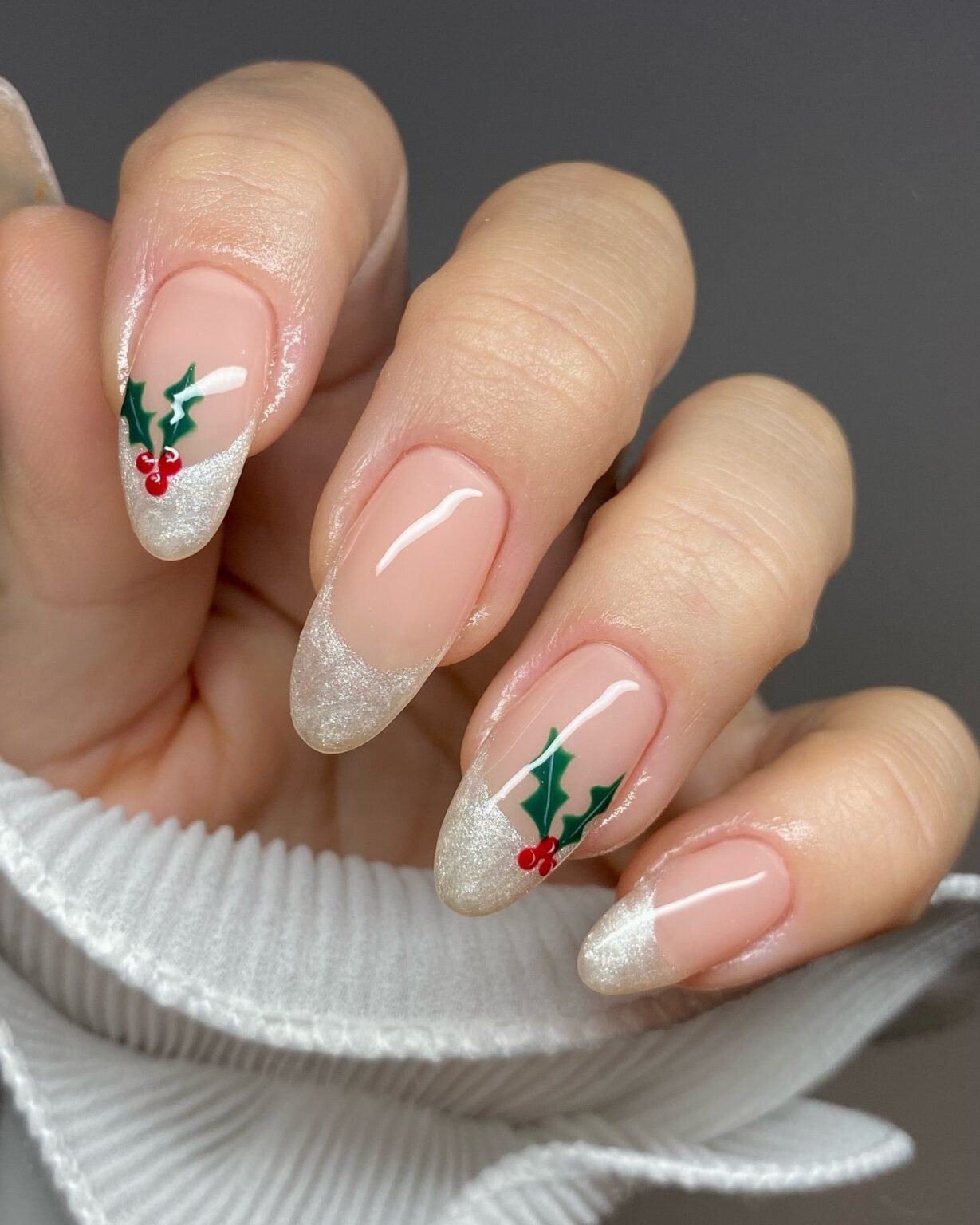 Short almond Christmas nails with silver glitter French tips and holly berry art