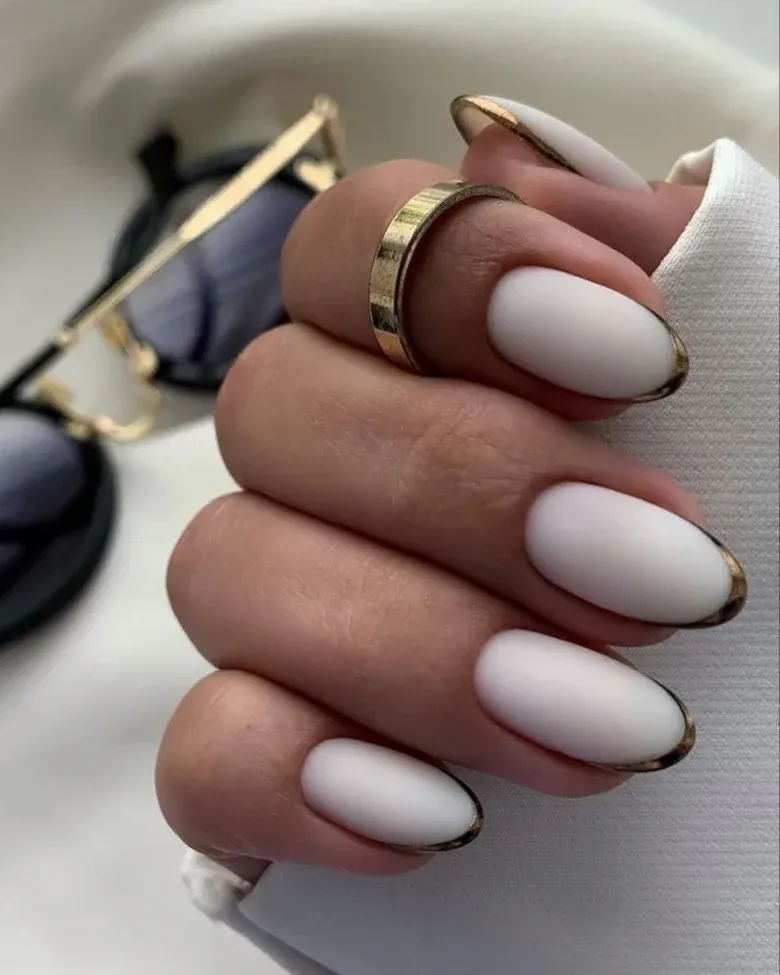 Matte white almond nails outlined with a thin gold tip
