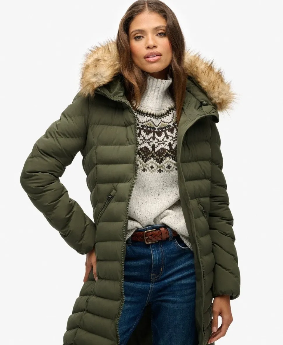 A woman wearing a faux-fur trimmed long puffer coat with a fair isle sweater