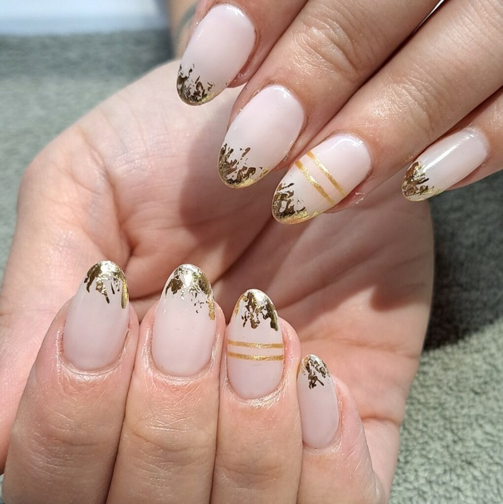 Nude nails with gold foil flake accents
