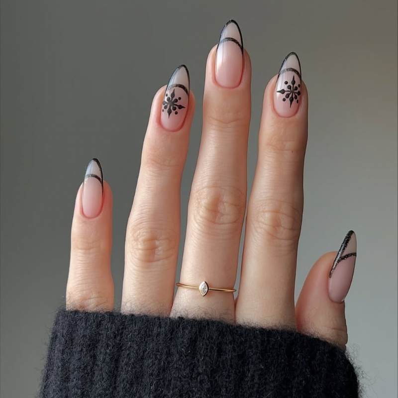 Almond nails with black French tips and black snowflake art