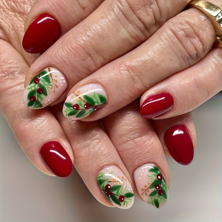 Deep red glossy nails with sheer nude accent nails painted with green leaves and red berries