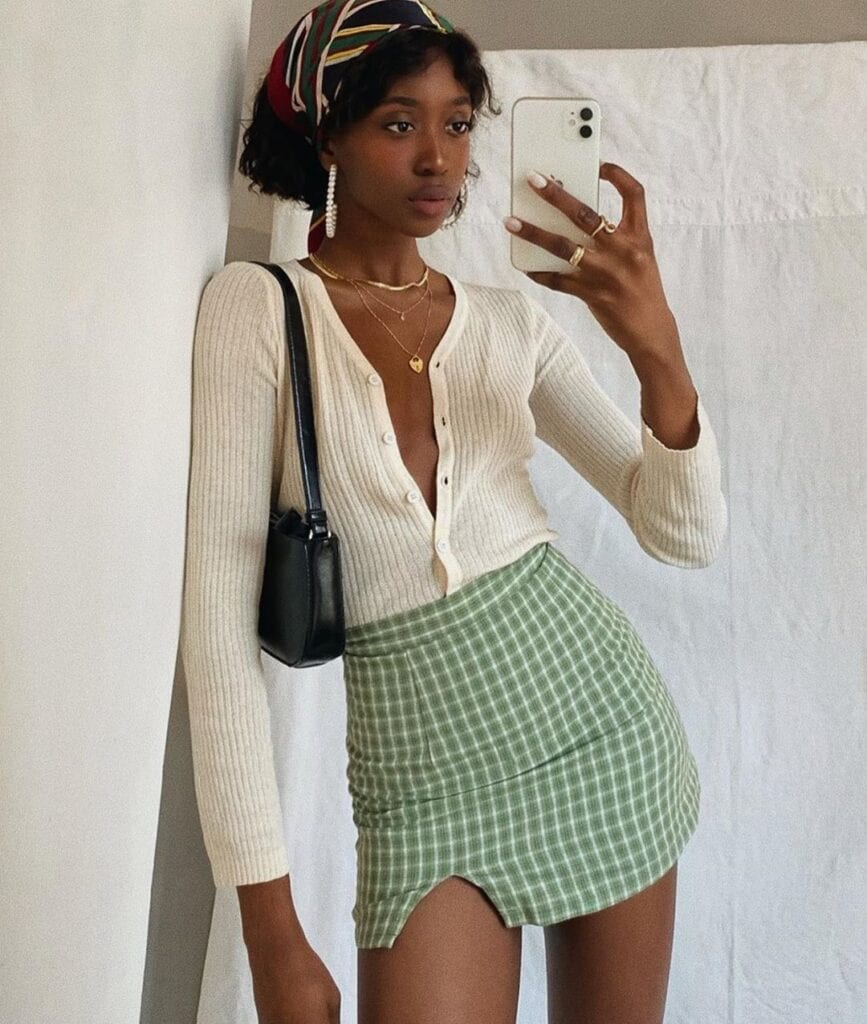 Cream cardigan with a green gingham mini skirt and headscarf
