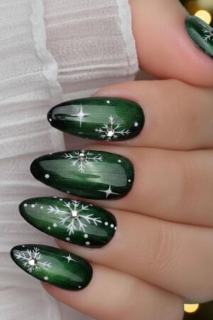 Deep green cat eye nails with snowflake nail art