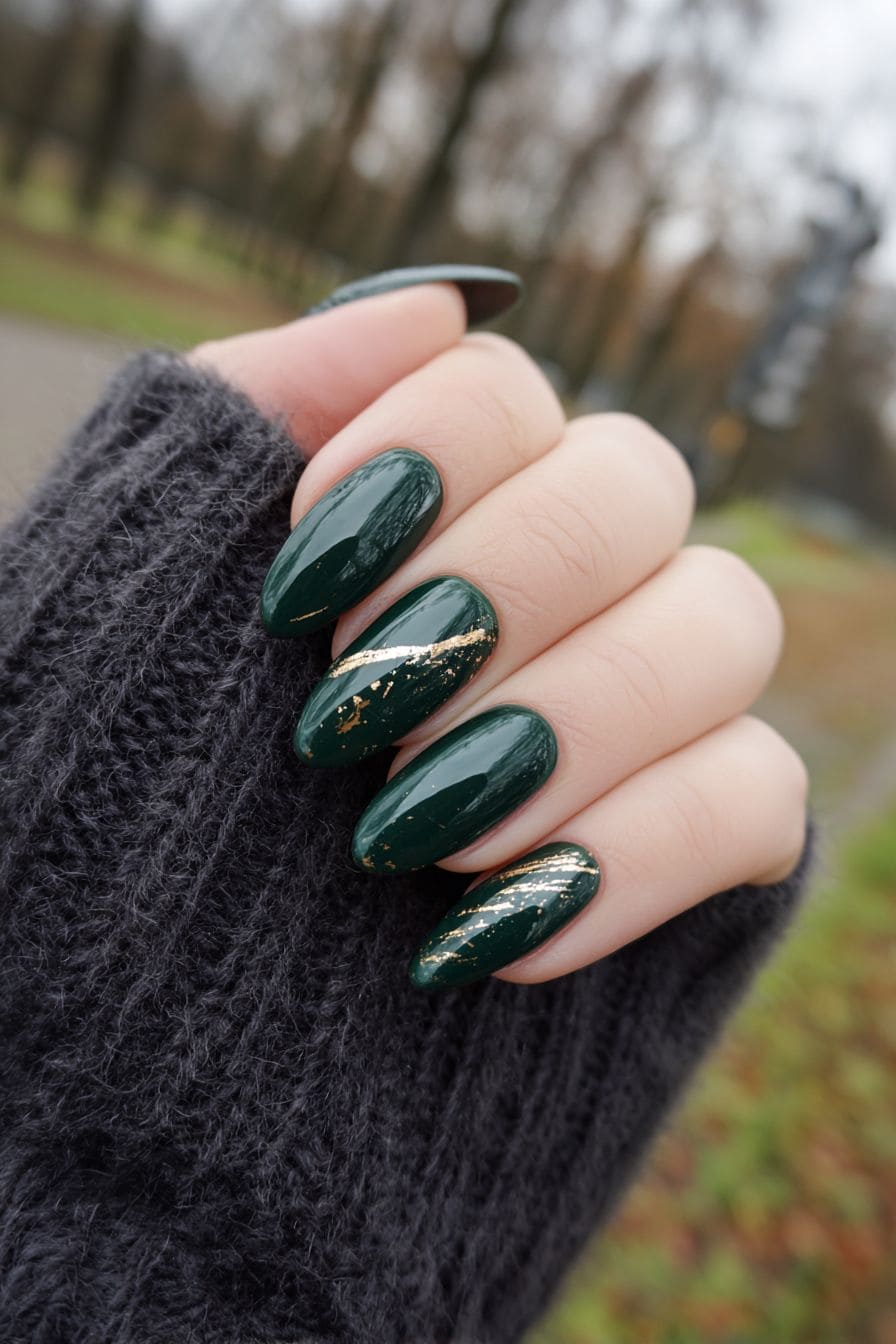 Long almond dark green nails with gold foil streak accents