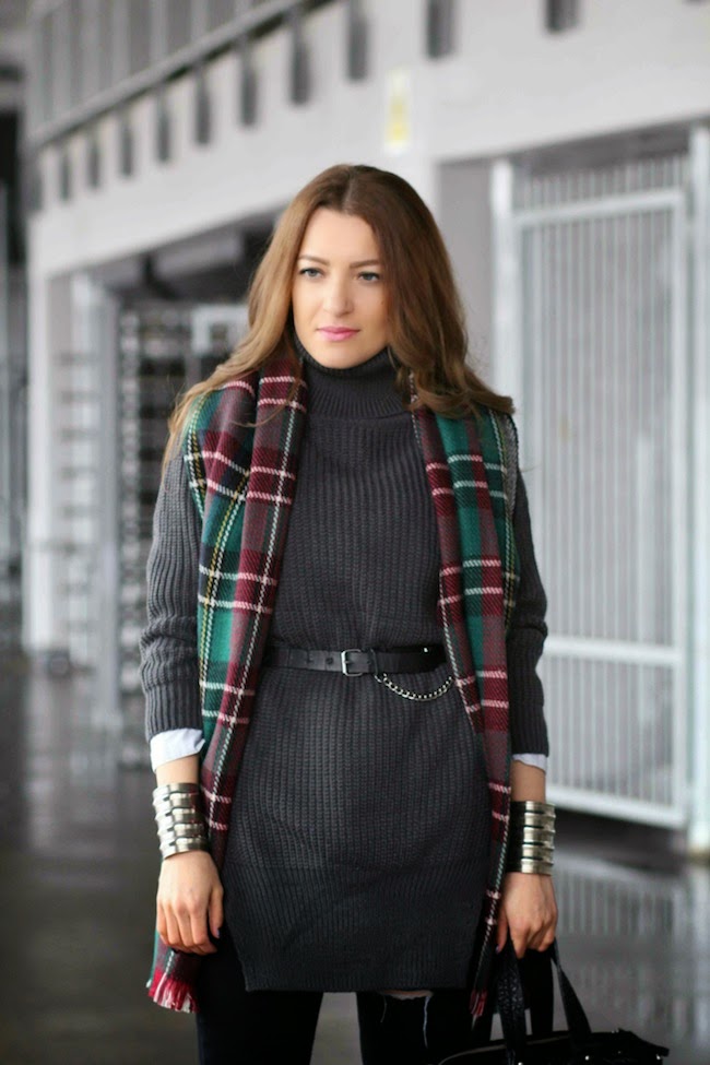 Dark grey ribbed turtleneck mini sweater dress with a black leather belt, a burgundy and green plaid blanket scarf and silver cuff bracelets