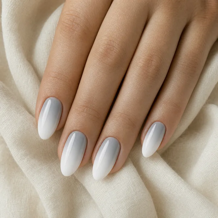 Almond nails with a light gray to white ombre fade and glossy finish