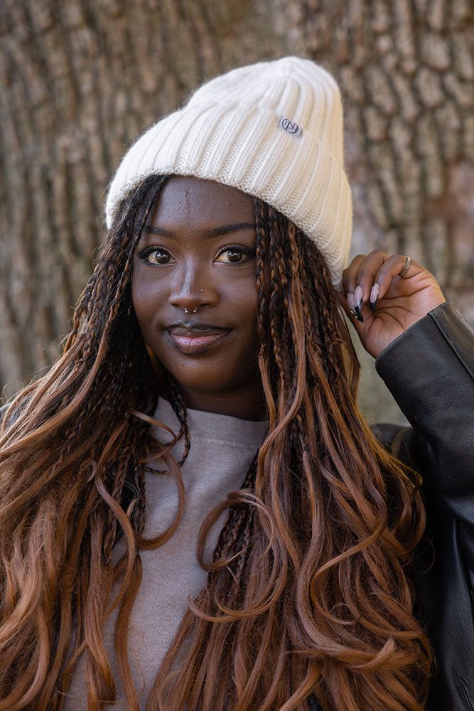 Woman in a white beanie with long ombre wavy goddess braids