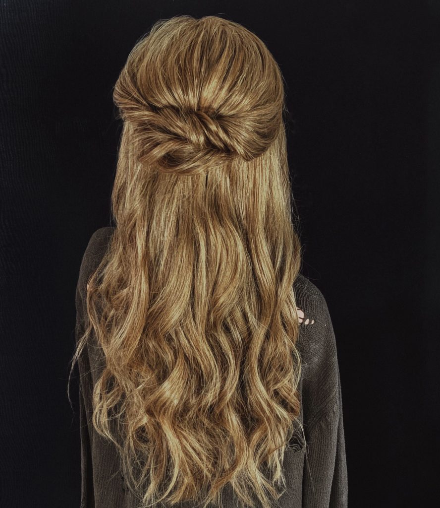 Half-up twisted knot on long wavy blonde hair