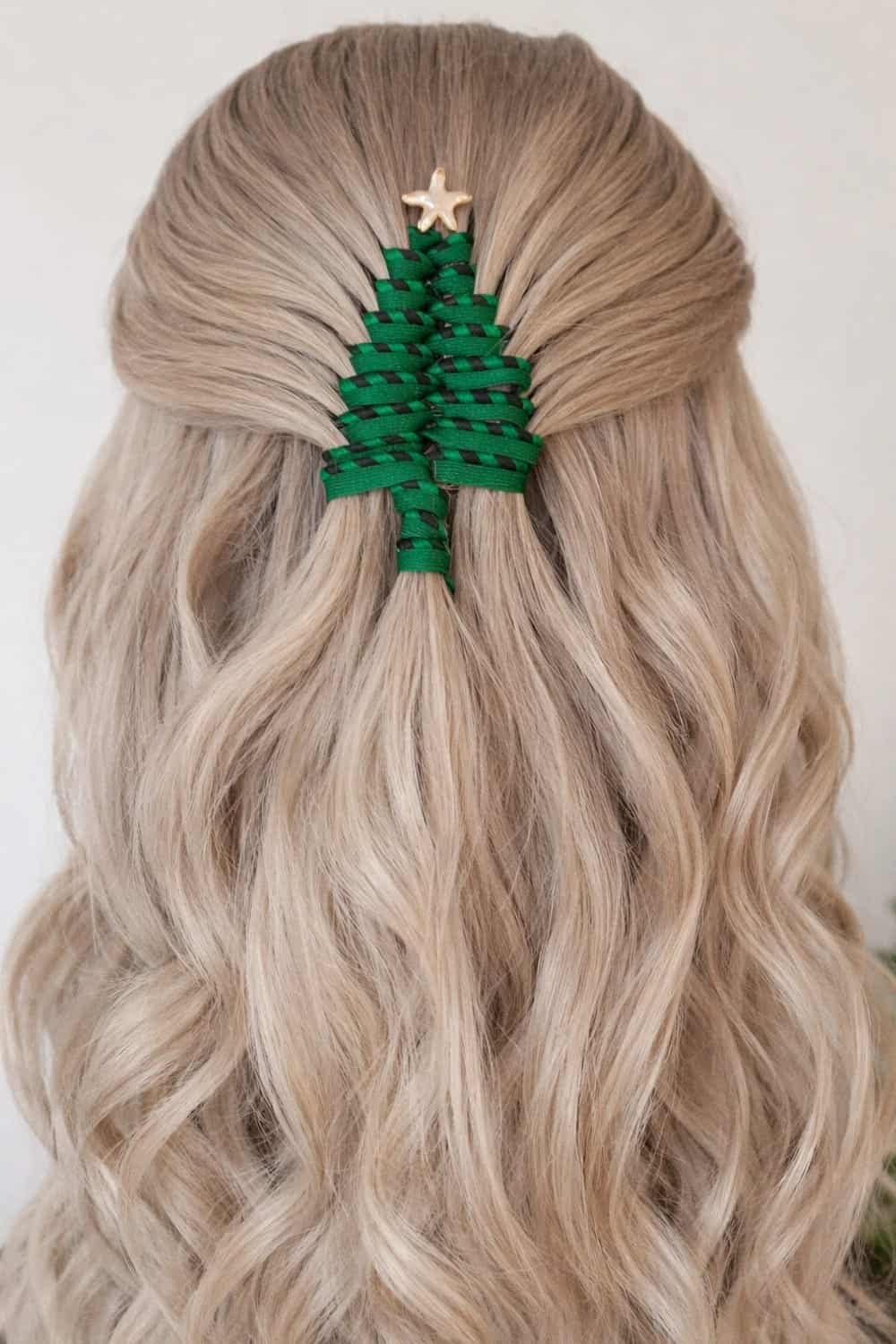 Half-up hairstyle with green ribbon woven through sections forming a Christmas tree shape with a tiny star