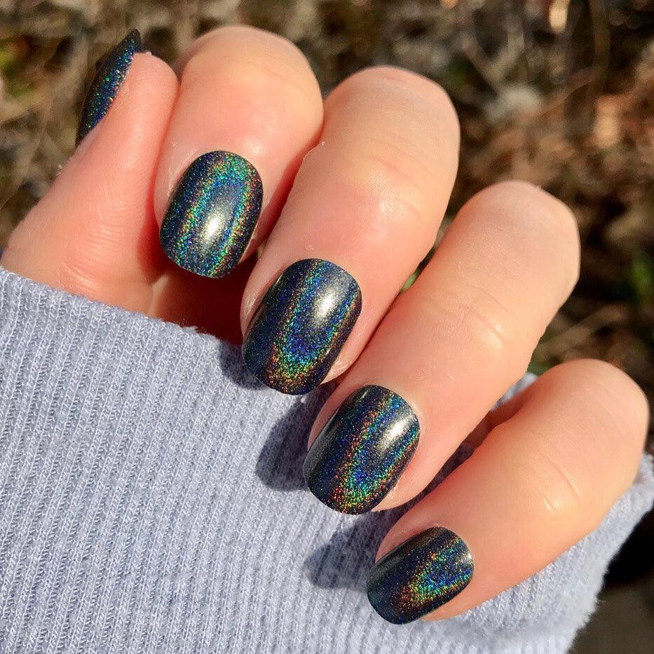 Short round black nails with subtle holographic sparkle