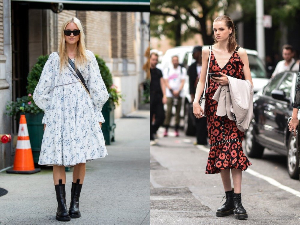 Two women on a street, one in a white floral babydoll dress and black chunky combat boots, the other in a red leopard slip dress and black combat boots