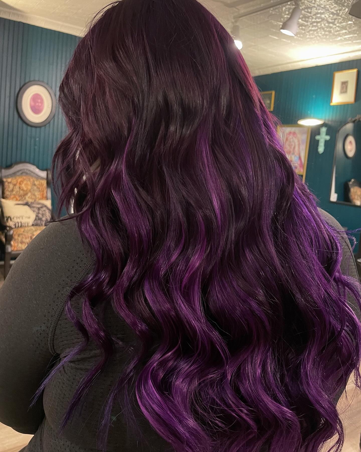 Back view of long wavy hair with dark brown roots melting into glossy plum-purple ends