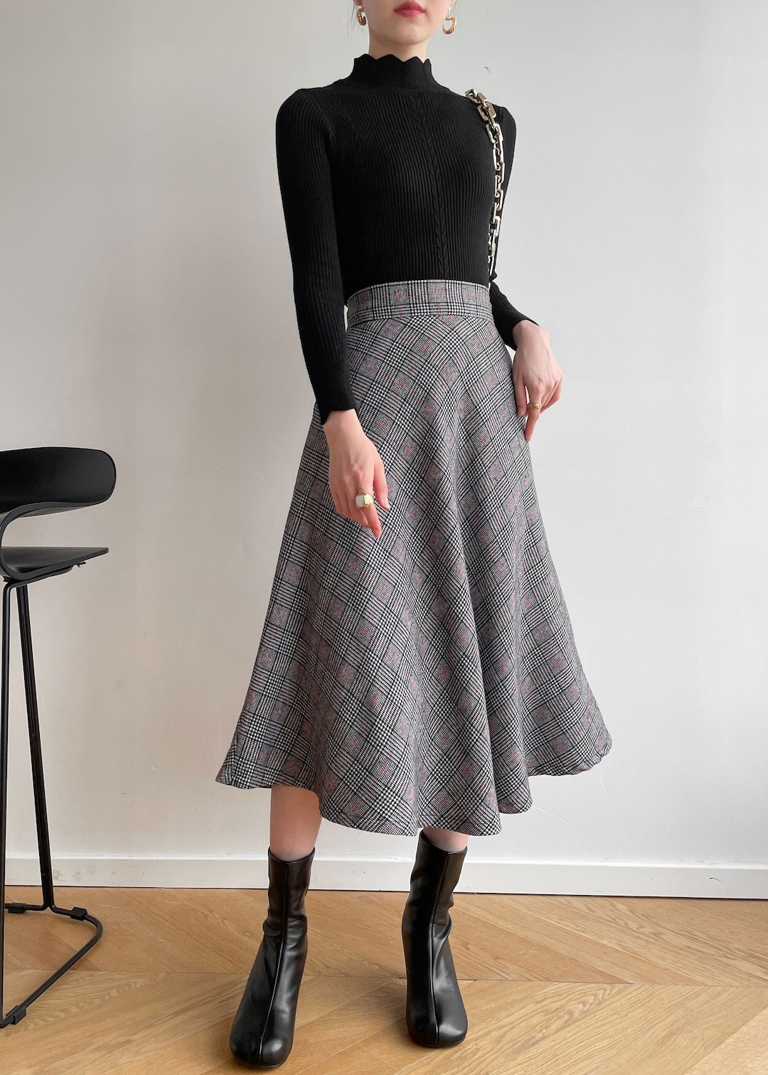 Black turtleneck paired with a plaid wool midi skirt