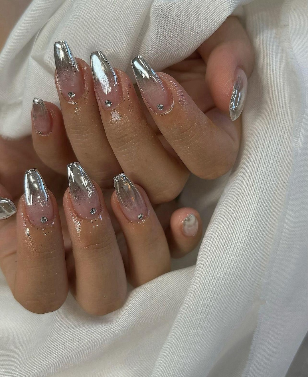 Silver chrome ombré nails fading from metallic to sheer