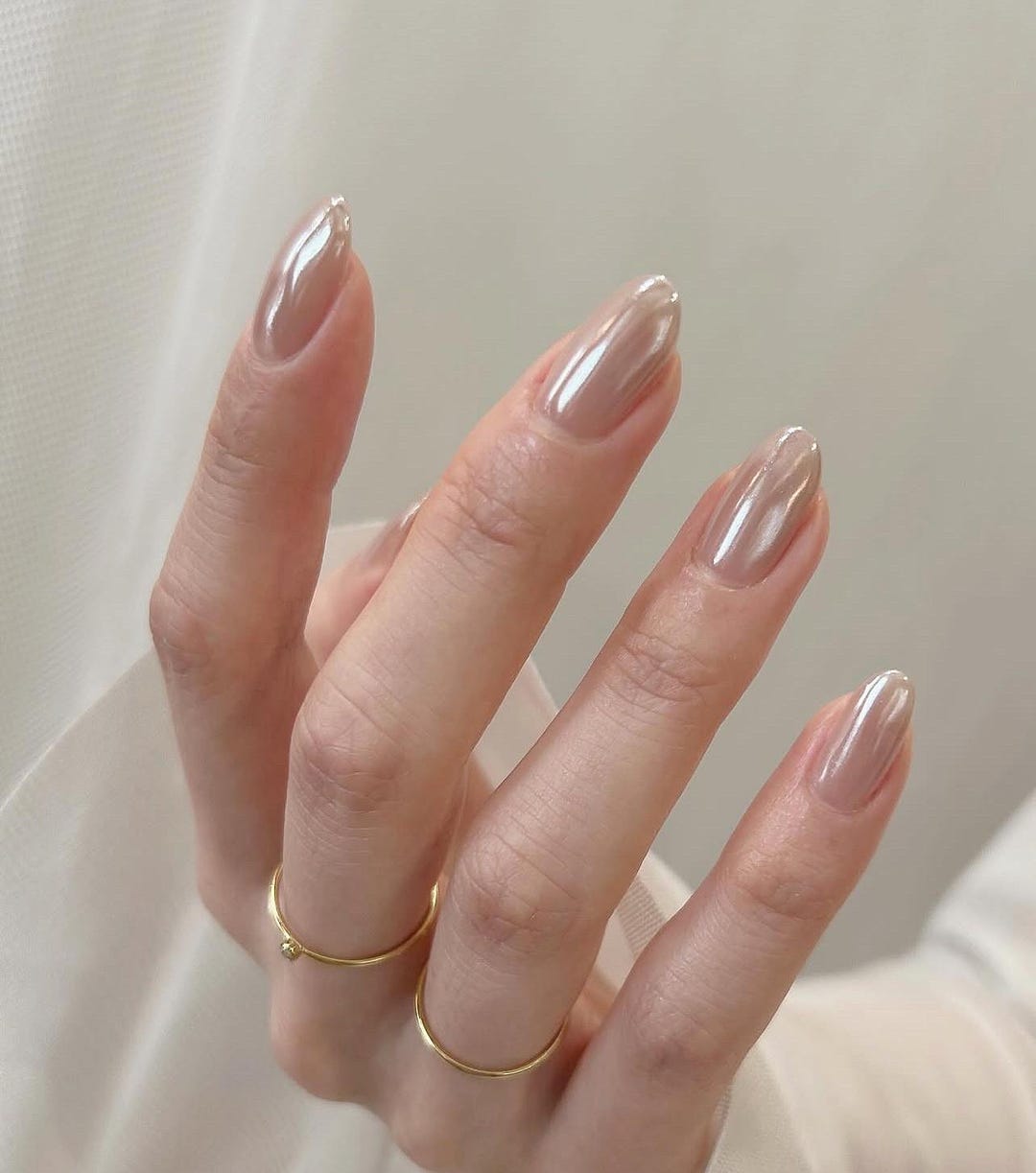 Medium almond nails in white pearl chrome with a soft iridescent glow