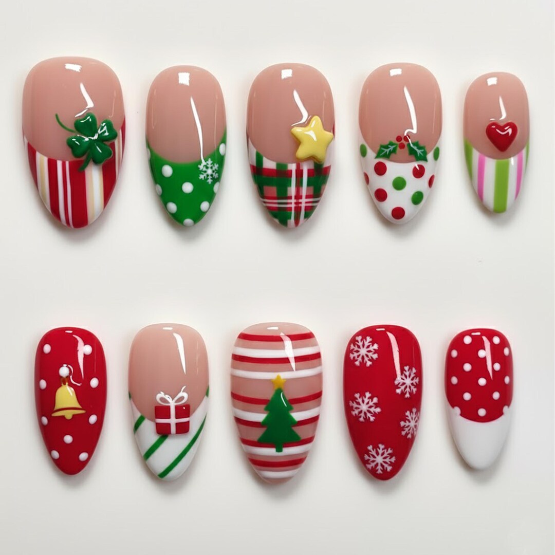 Press-on nails with mixed Christmas motifs including a tree, gift box, holly and snowflakes