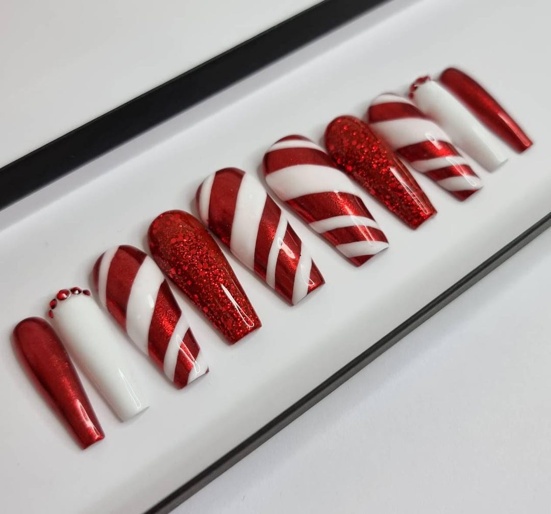 Candy cane press-on nails alternating red glitter, white, and diagonal stripes