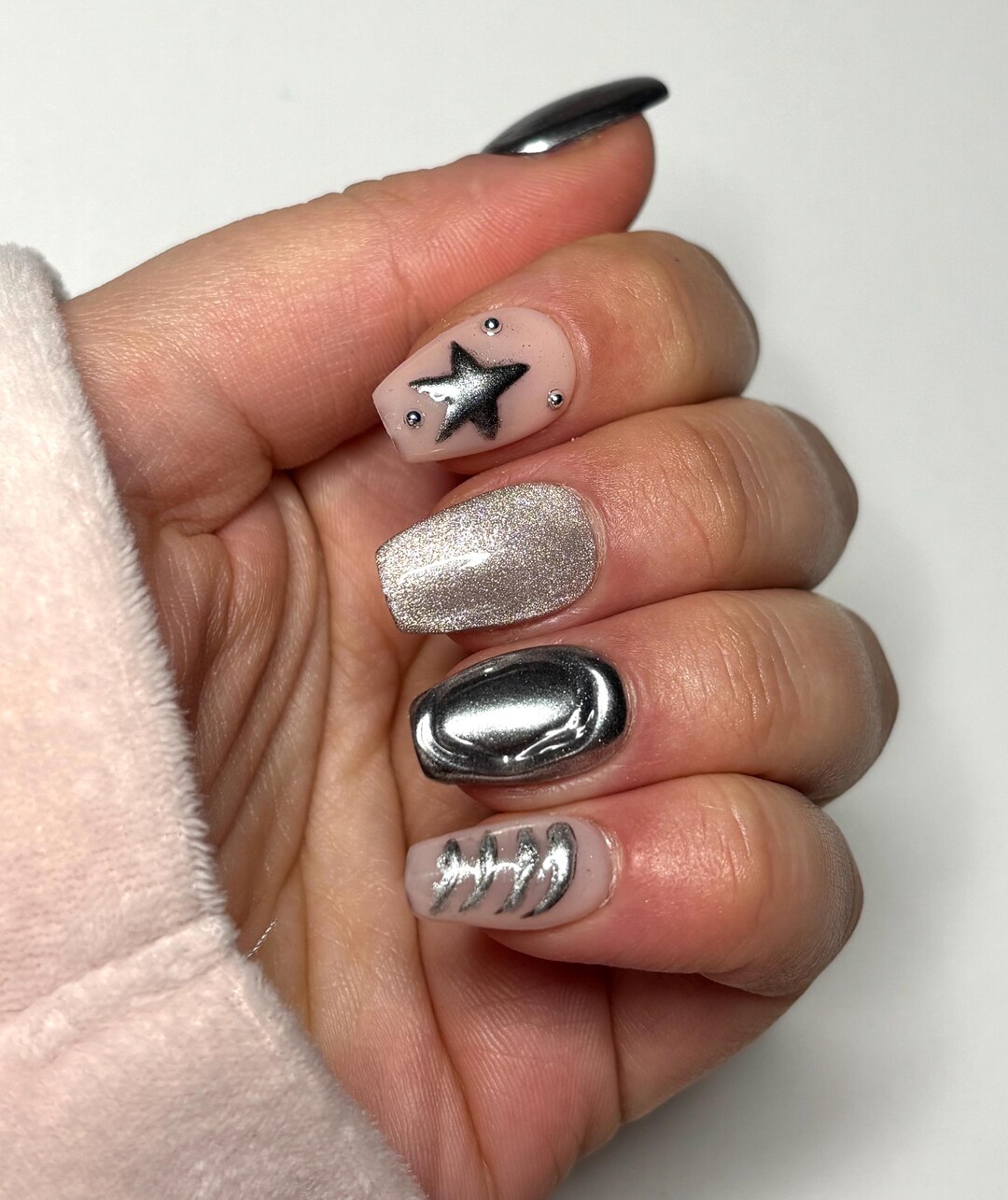 Silver chrome nails with glitter accent and chrome star nail art