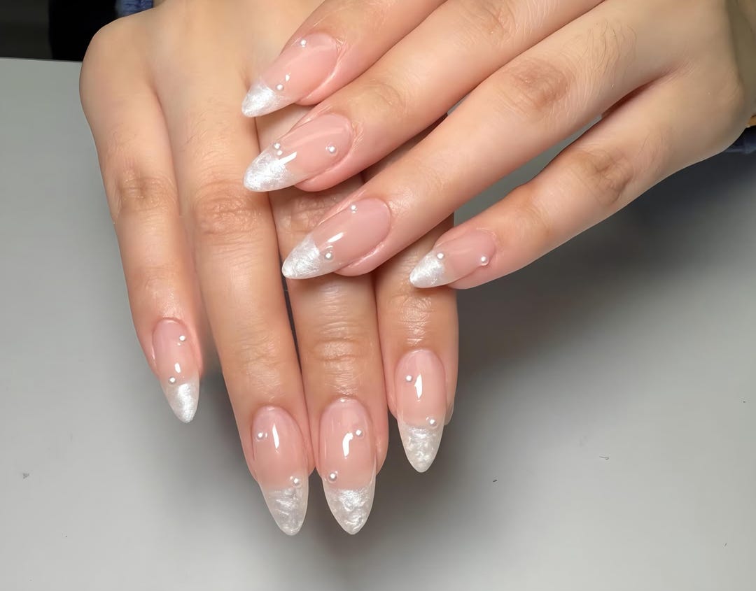 Pearly white French tip nails with delicate pearl accents