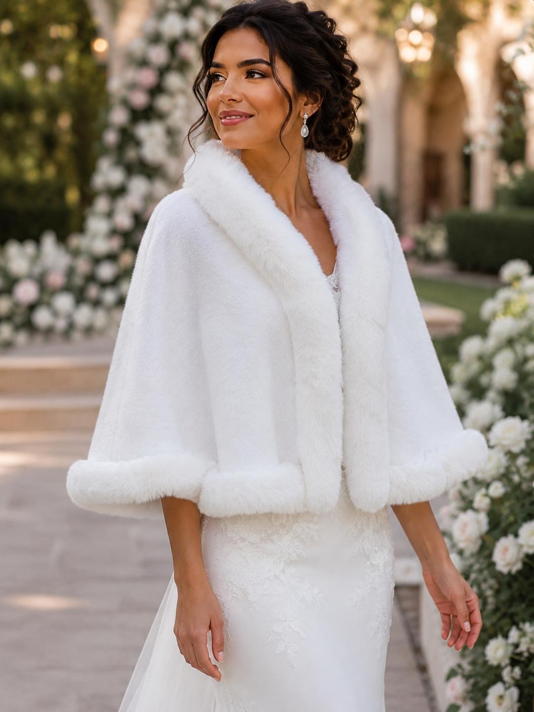 Woman wearing an ivory faux fur cape over a white evening gown