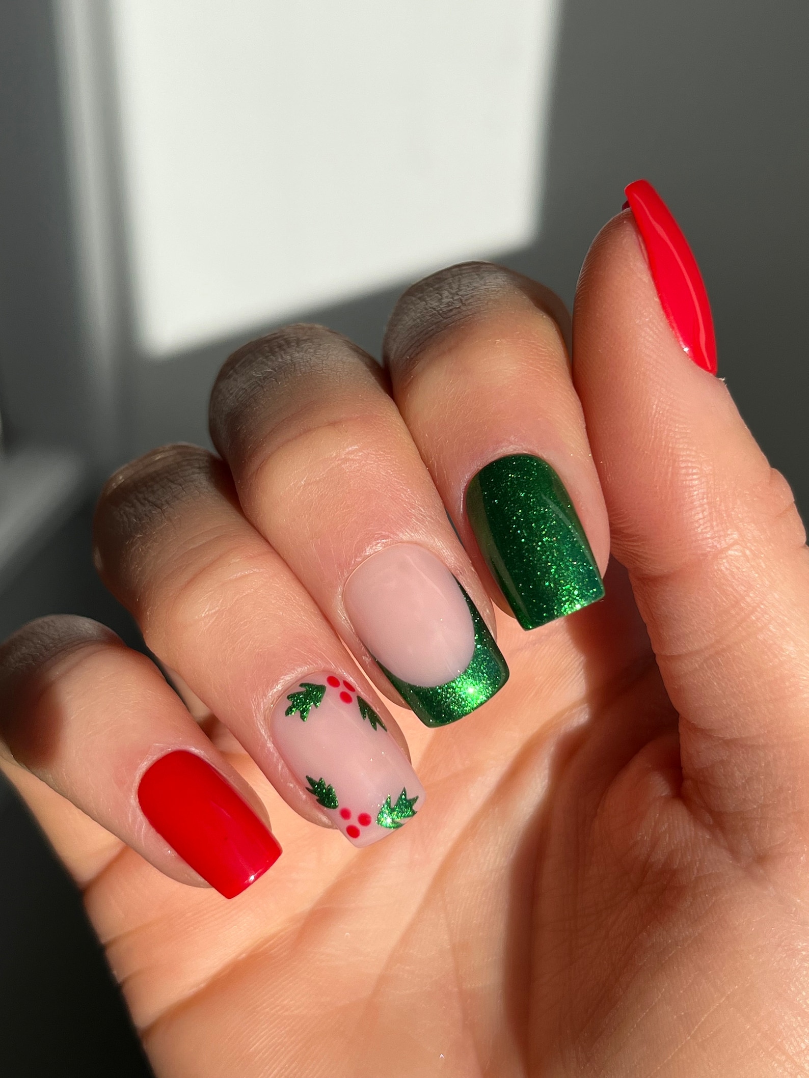 Mixed red and green Christmas nail set with holly art, green glitter and solid red nails