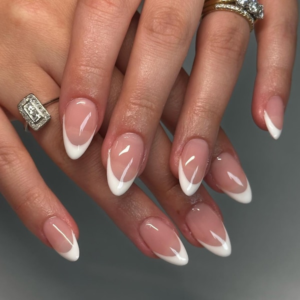 Classic white French tip press-on nails in almond shape with nude pink base