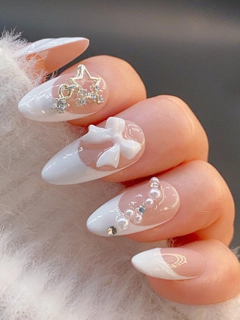 White almond press-on nails decorated with delicate bow charms