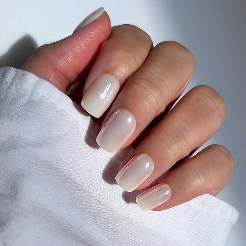 Short nails in snowy white polish with a pearlescent shimmer