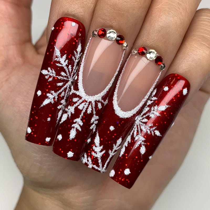 Red nails with white snowflake nail art