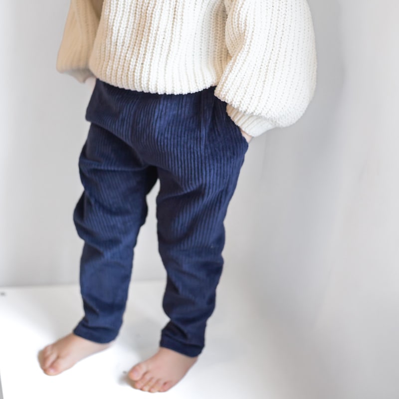 A child in a chunky knit sweater with corduroy pants for winter