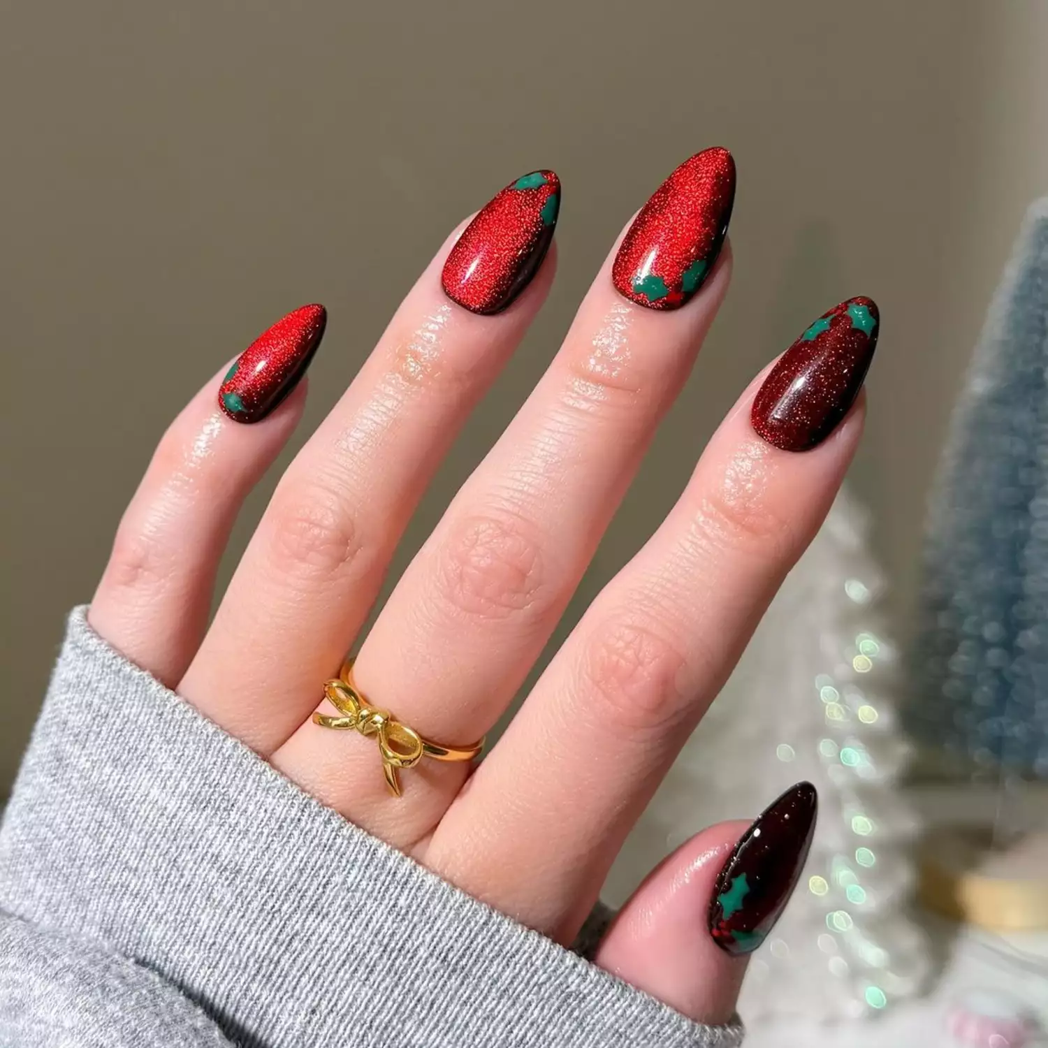Shimmery red nails with green holly leaf accents