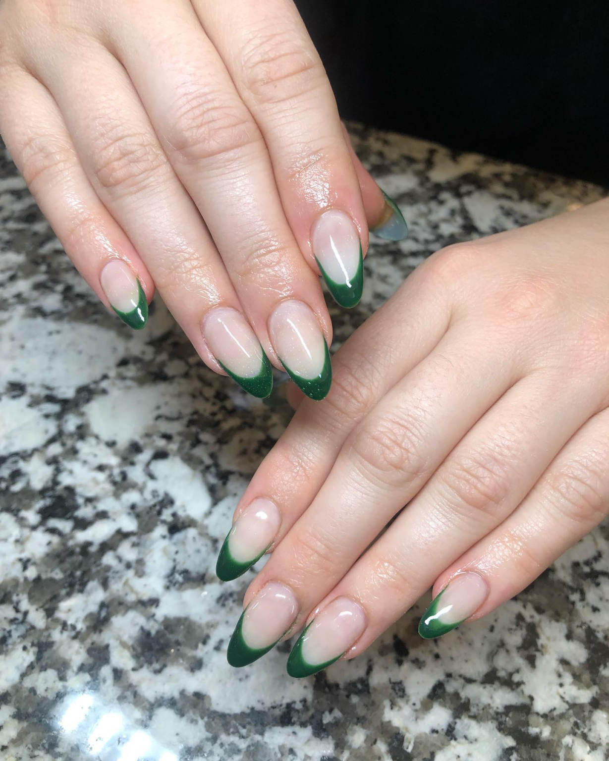 Forest green French tips on sheer nude long almond nails