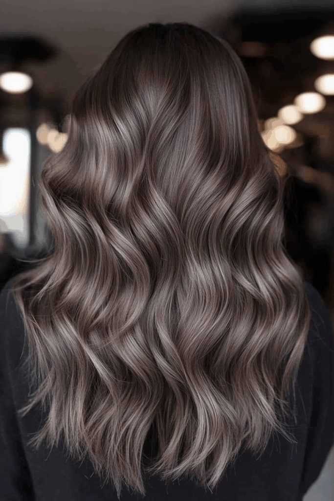 Back view of long wavy hair with ash silver cool-toned balayage over a dark base