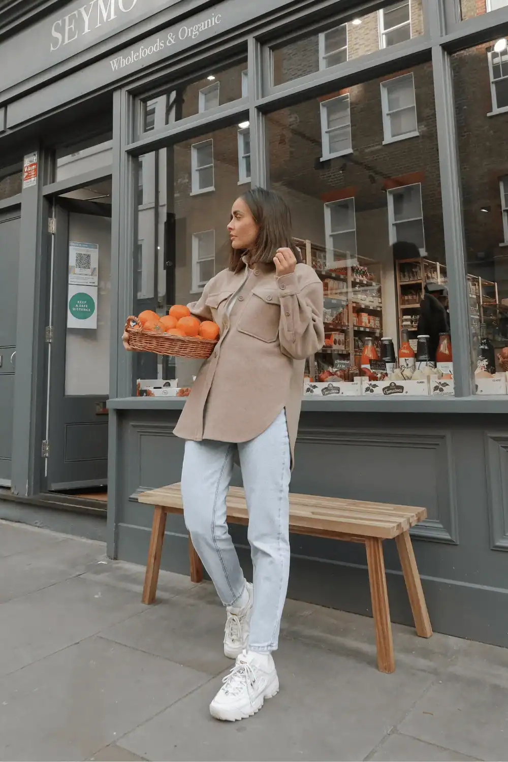 Woman in a shacket with jeans and sneakers