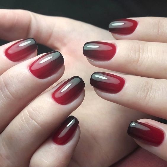 Short squoval nails with a black-to-red ombre gradient