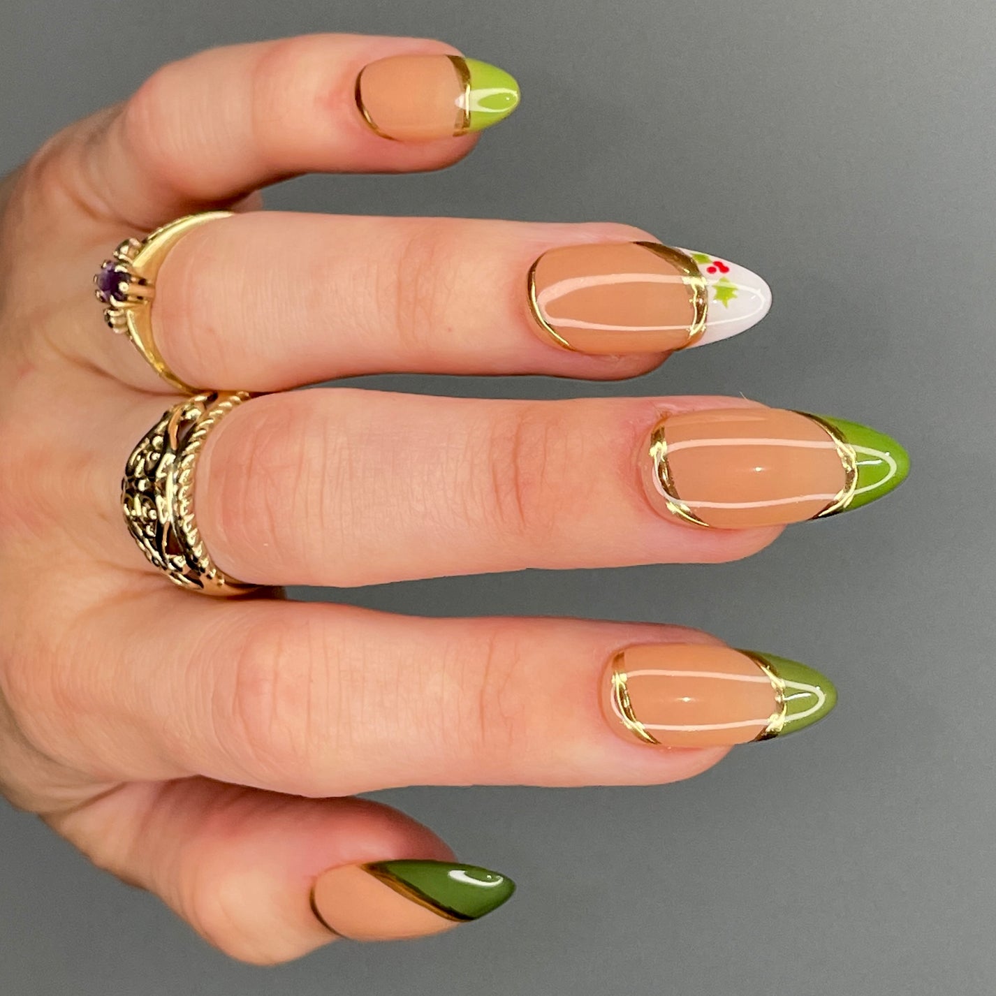 Sheer nude almond nails with hand-painted holly berry art