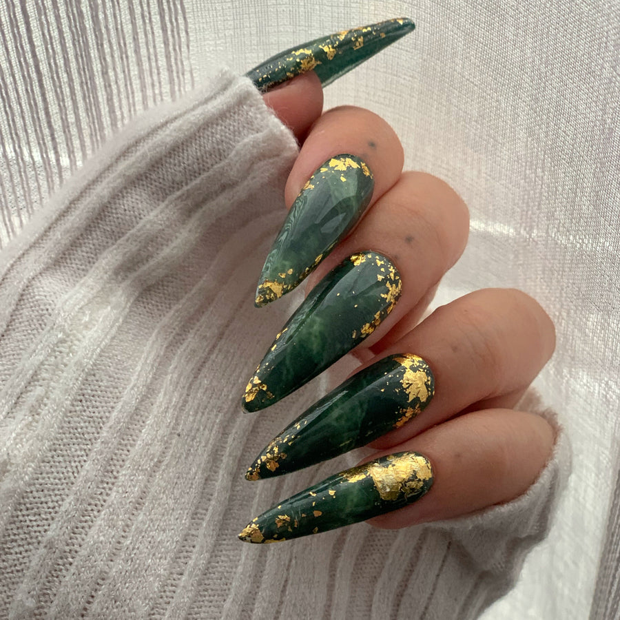 Oval nails in deep green with crushed gold flake accents