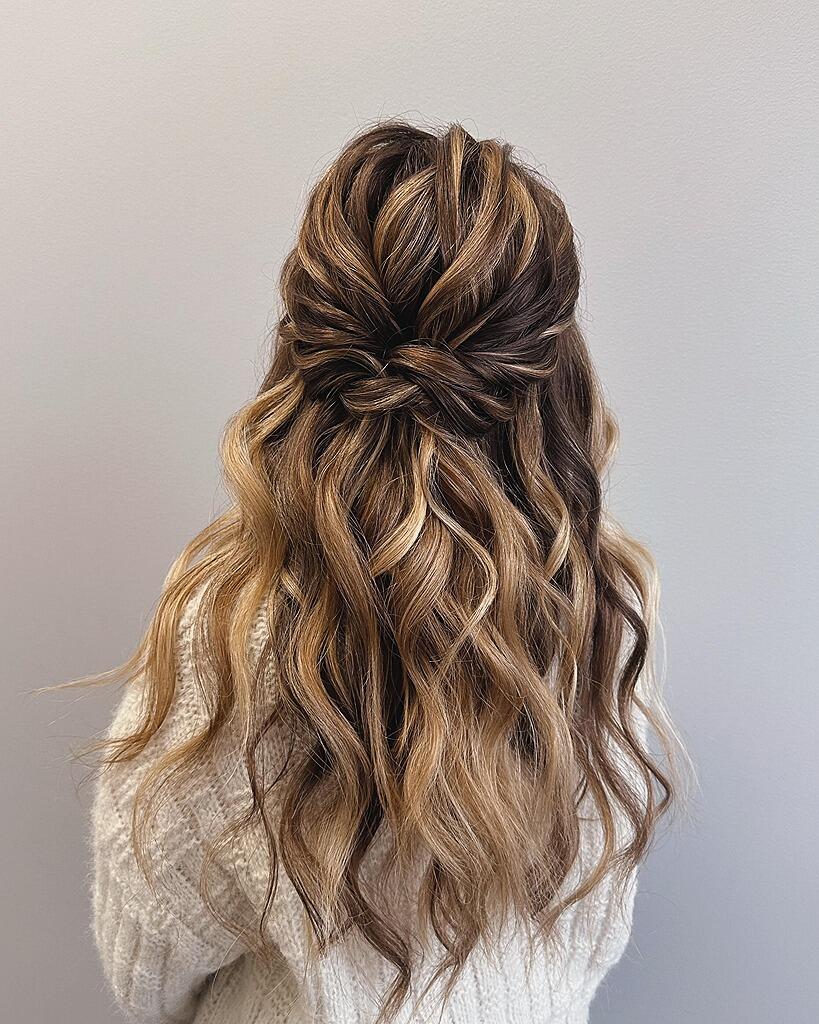 Woman with a half-up twisted hairstyle on long wavy hair