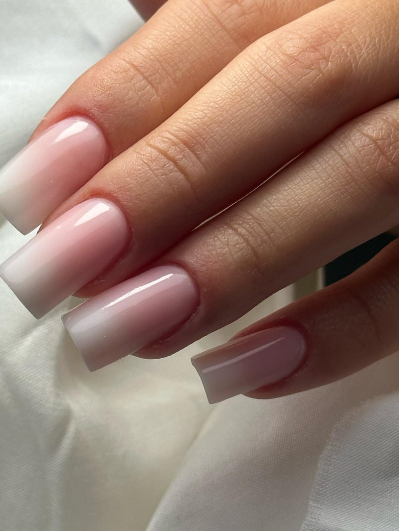 Long square nails with a baby boomer gradient from blush pink at the cuticle to white tips