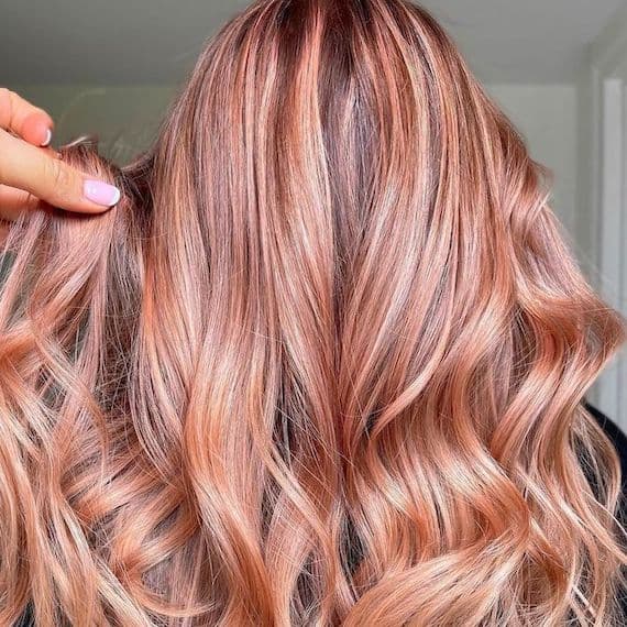 Long wavy rose gold blonde hair with copper lowlights, back view