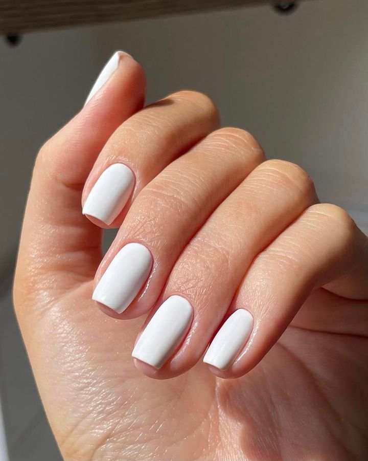 Short square nails painted in a crisp ivory white polish