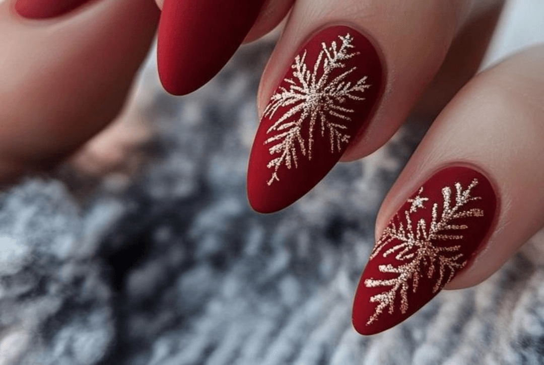 Matte cranberry almond nails with a glossy snowflake accent nail