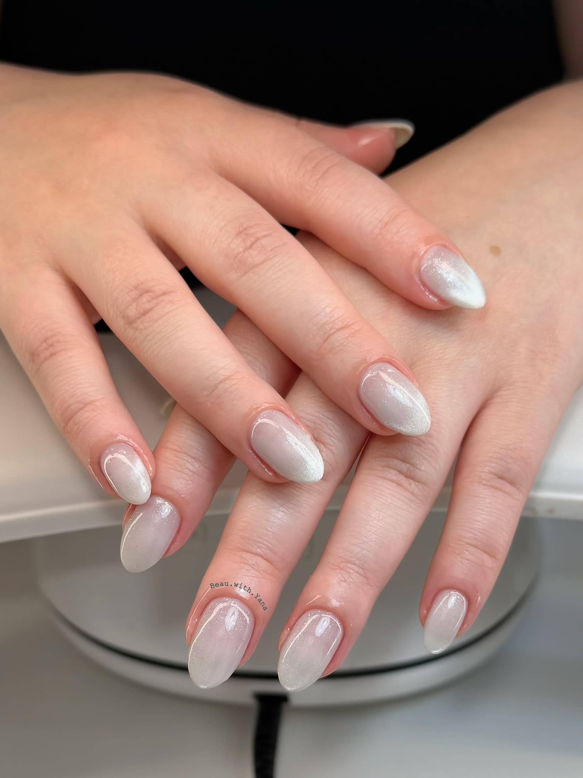 Almond nails in milky white with a subtle cat-eye magnetic shimmer