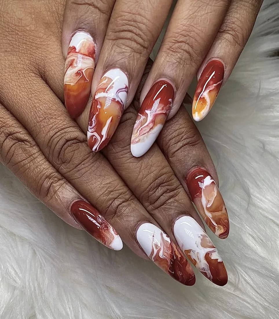 Long nails with cherry red marble swirls mixed with cream