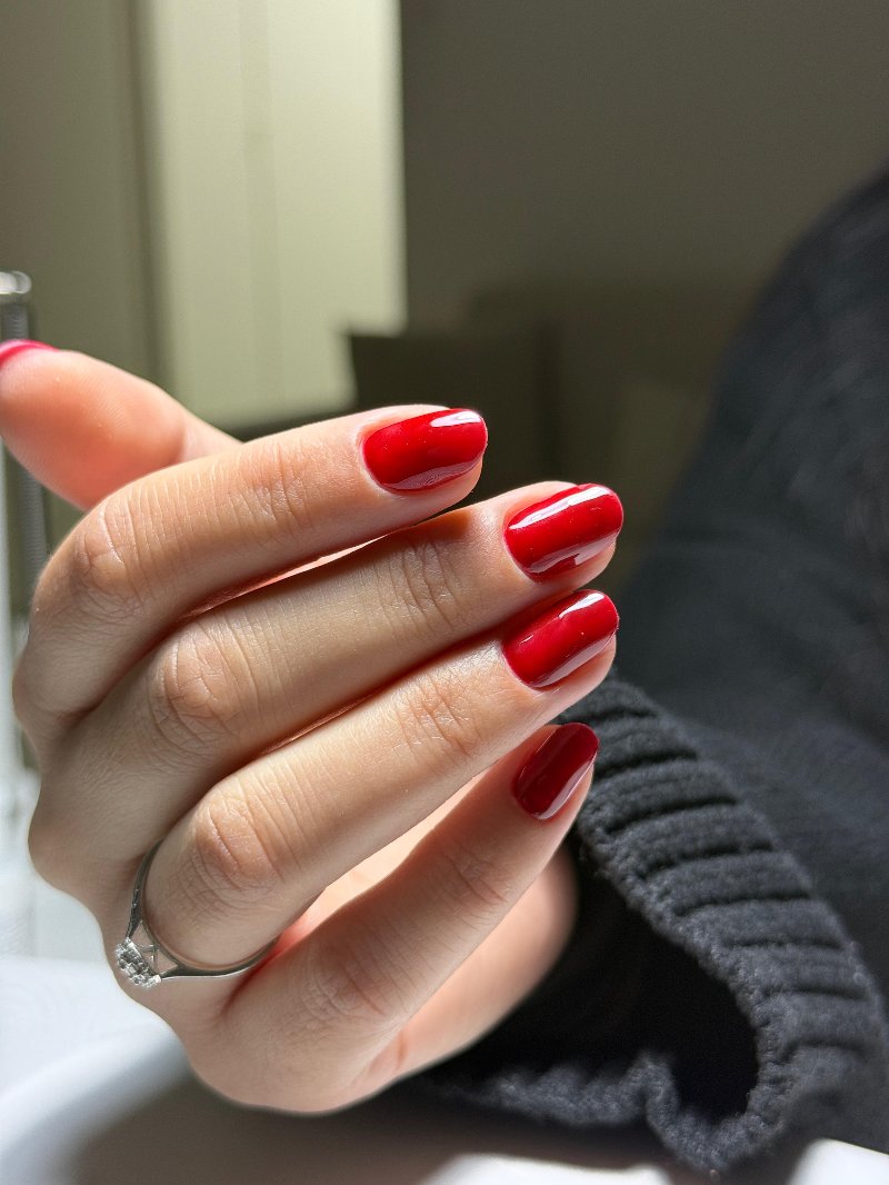 Short round nails with glossy classic red gel polish