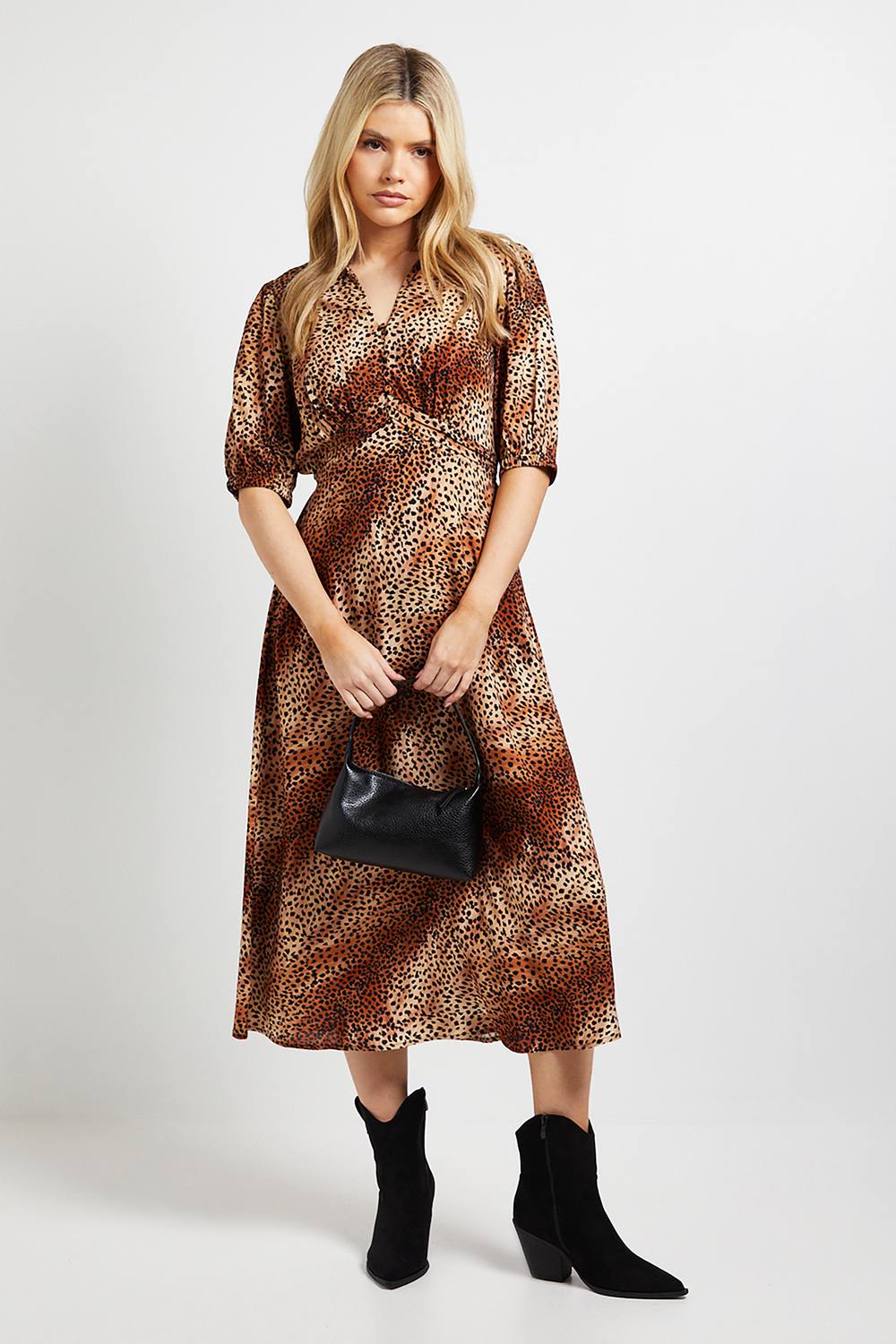 Woman wearing black suede pointed ankle boots with a leopard-print wrap midi dress