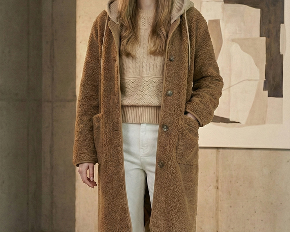 Woman in a teddy coat over a cream knit set